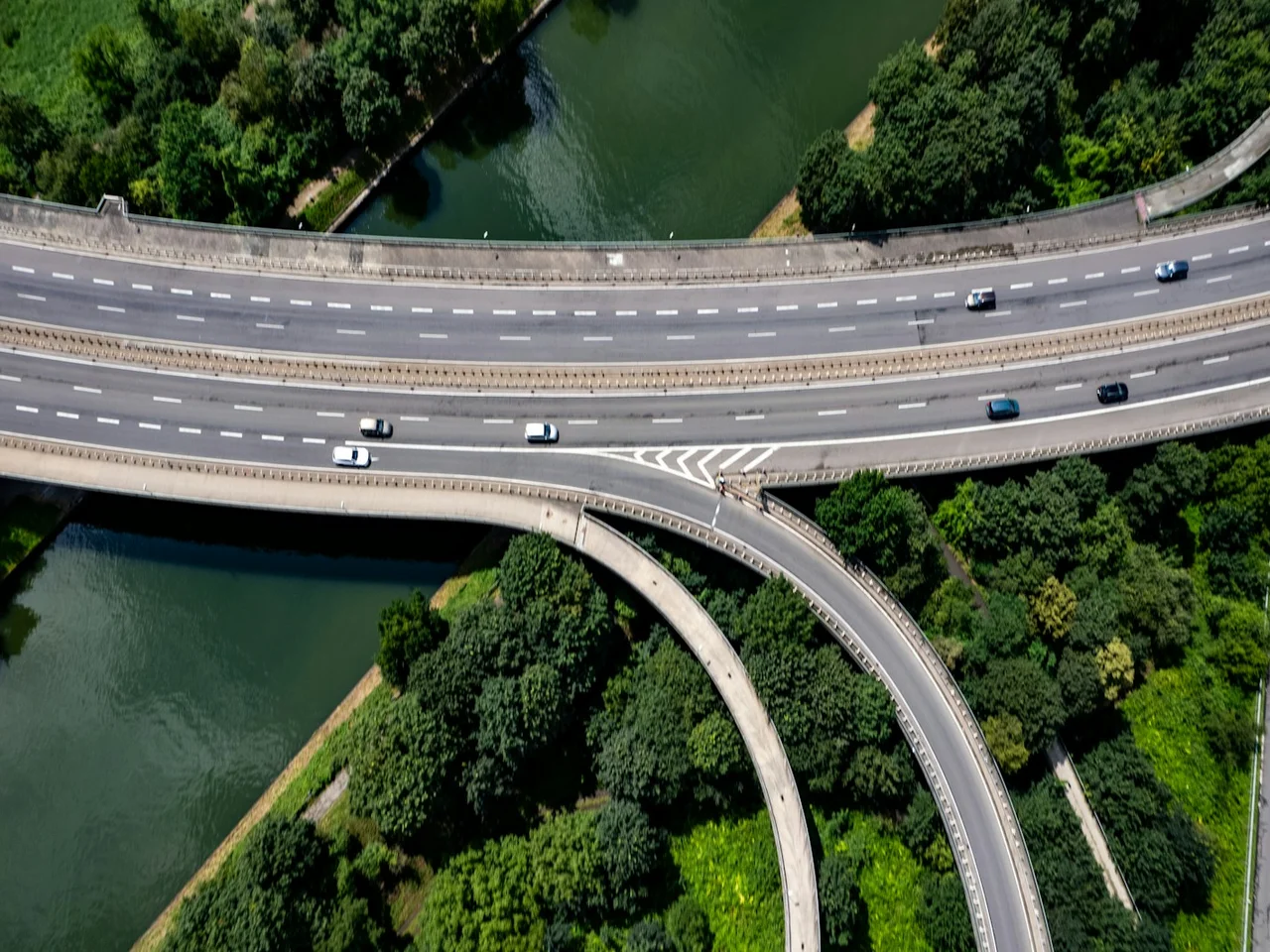 Aerial view of a highway, river, and surrounding urban areas, representing spatial comparison.